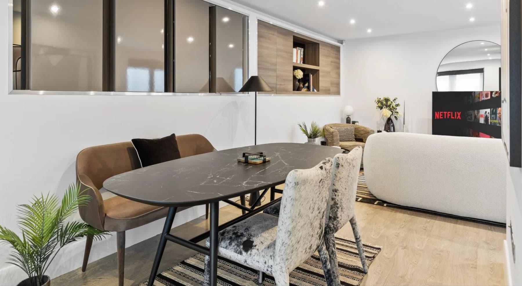A thoughtfully furnished London residence with a marble dining table and a bright living area